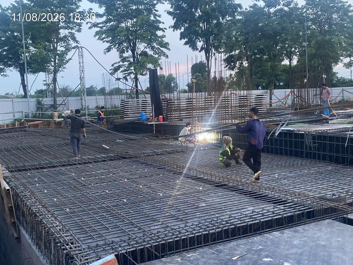 Công nhân thi công sàn cốt thép lúc hoàng hôn, dự án NOXH Minh Đức ngày 11/08/2026